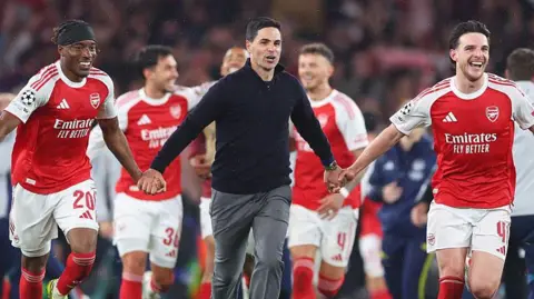 Manager Mikel Arteta celebrates with Arsenal players after they reached the 2026 Champions League final