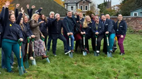 BBC Staff, supporters and Ian Byrne MP (fifth from right) seen with spades ready to break the ground for the new children's hospice in Liverpool.