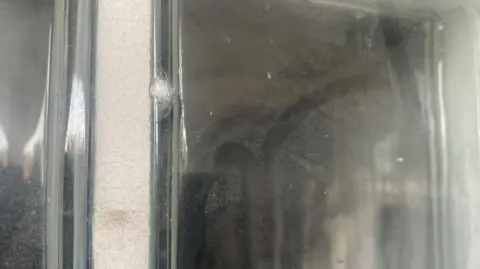 A pane of glass which has been damaged by the shooting