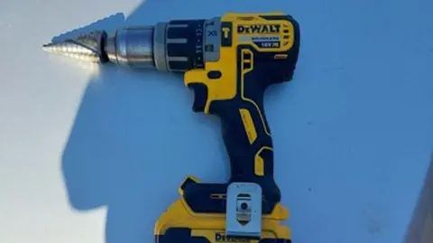 A drill laying on a flat surface