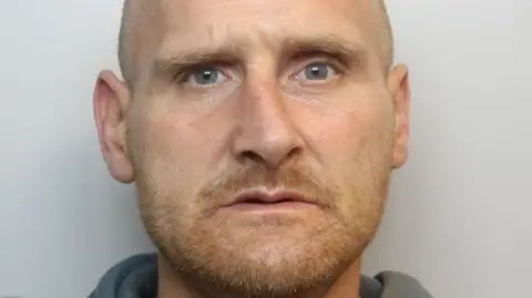 Wiltshire Police Mug shot of Timothy Cooper. He has a ginger beard and is bald.