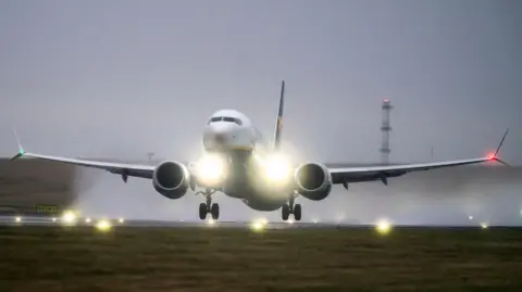 Image shows a plane landing at an airport. 
