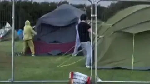 Festival-goers holding on to tents