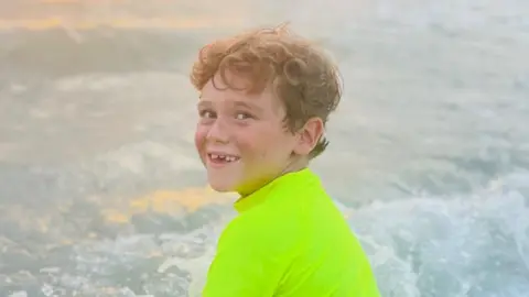 Alfie Kiely Alfie in a neon green swim top in the sea