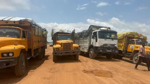 IOM/REUTERS Trucks carrying aid for Sudan's Darfur region, at a location believed to be the border between Chad and Sudan.