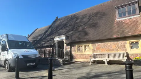 A former church building with an Age UK van parked in front