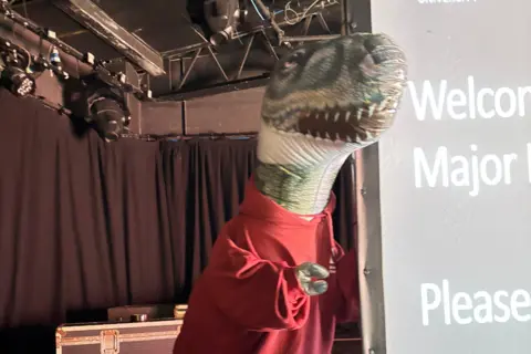 BU A blow up Godzilla in a red hoodie.