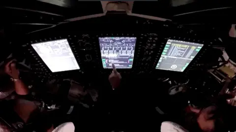 NASA Astronauts pointing at a screen inside the Orion spacecraft