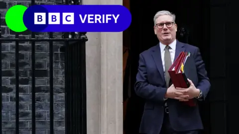 BBC Keir Starmer walking out of the door of 10 Downing Street carrying three folders. The BBC Verify lozenge is in the top left corner.