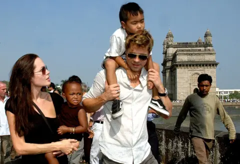 Getty Images Pasangan ini berfoto bersama dua anak mereka, Maddox dan Zahara, saat berada di Mumbai, India, tempat Jolie syuting A Mighty Heart pada tahun 2006