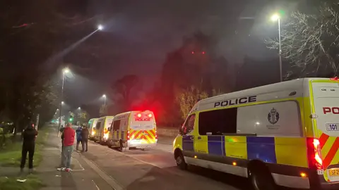 A police helicopter flies overhead as police roadblocks are set up