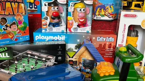 Toys piled high including Mr Potato Head, the floor is lava game, playmobil and small table football table