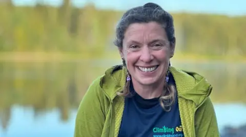 Kelda Wood Kelda Wood in a green hoodie and blue tshirt, smiling in front of a lake