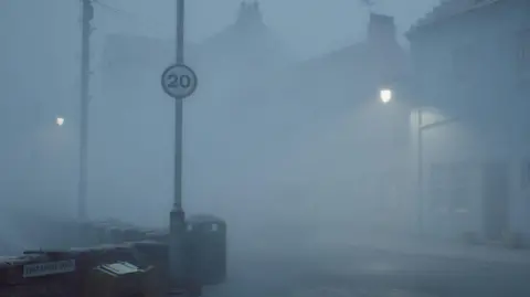 Screen Burn/Konami/Annapurna Video game graphic of a residential street cloaked in fog with a 20mph sign on a lampost