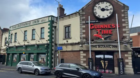 The Botanic Inn is a yellow and green building. 