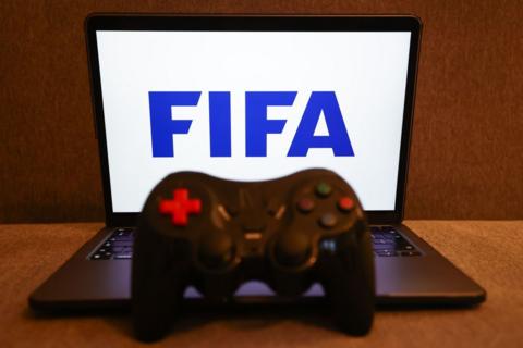 FIFA logo displayed on a laptop screen and a gamepad.