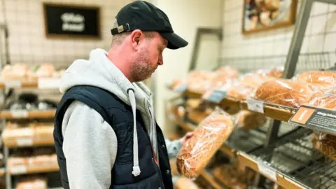 Getty Images Man looks at loaf of bread 