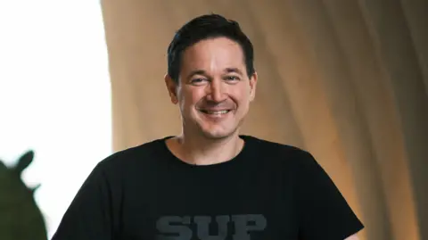 Ilkka Paananen smiling and wearing a black t-shirt