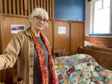 Woman standing in front of a large patchwork coat