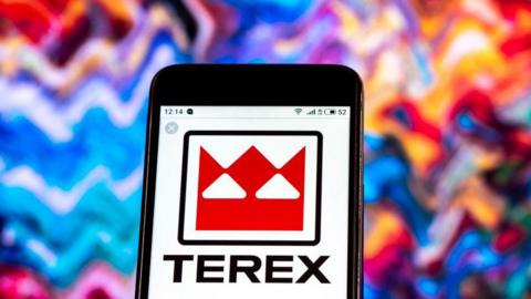 Terex company logo on a phone screen. The logo is red and white and has Terex in bold, black letters beneath it. The background behind the phone is multicoloured.