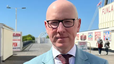 Patrick Hurley, wearing glasses and a blue jacket