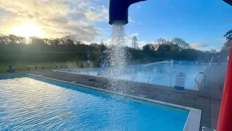 Jubilee Park Woodhall Spa Two outdoor pools. One is being sprayed with a large water tap. 