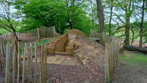 National Trust/Richard Saunders The entrance to Knole icehouse as seen before reconstruction. There is no gate and the bricks are slightly untidy.