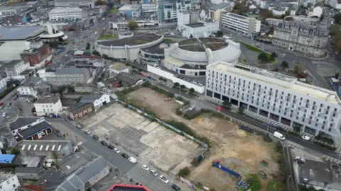 Ariel shot of the building site between Bath Street and Martin Street in Millbay, Plymouth. There are buildings around the area, and an empty space at the centre, which is the building site.