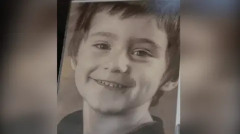 Family handout An image of a framed black and white photograph of Daniel Klosi, a four-year-old boy with short brown hair smiling at the camera