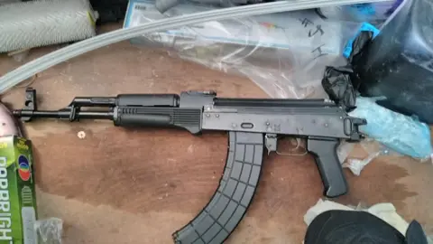 GMP A photo of a machine gun, surrounded by plastic, that police found during their investigation