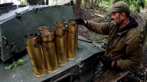 A soldier examines spent tank shells