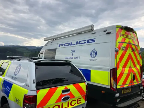 BBC Police dive and marine unit van and pick-up parked side by side by the side of Loch Ard.