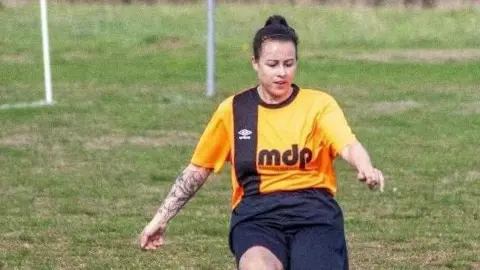 Holly Bedford in an orange and black Plainmoor Ladies FC kit 