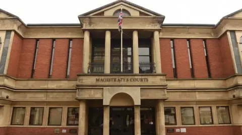 PA Media Leicester Magistrates' Court with a Union flag flying above the court sign
