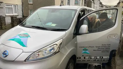 BBC News John Barrington Powell is helped into a Dolen Teifi vehicle by the driver 