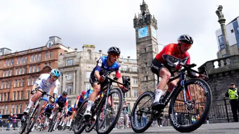 Ally Wollaston of team Suez (centre left) passes the Tolbooth Steeple during stage four of the 2025 Lloyds Tour of Britain Women in Glasgow