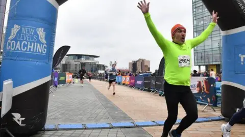 Runner crosses the blow-up finish line at Media City