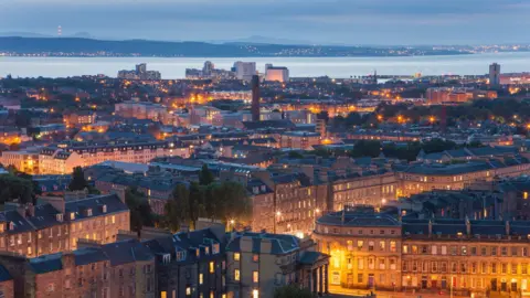 Getty Images Image taken from Edinburgh's Calton Hill, looking north over the rooftops across Leith towards the Firth of Forth. Picture taken at dusk with the buildings nicely lit up by street lights