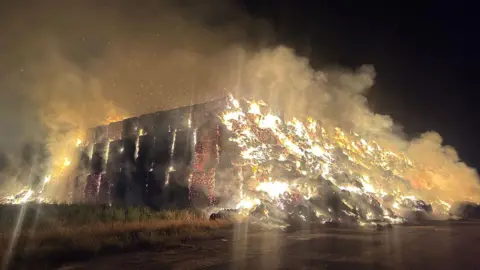Nottinghamshire Fire and Rescue Service A large stack of hay bales on fire in the middle of the night. 