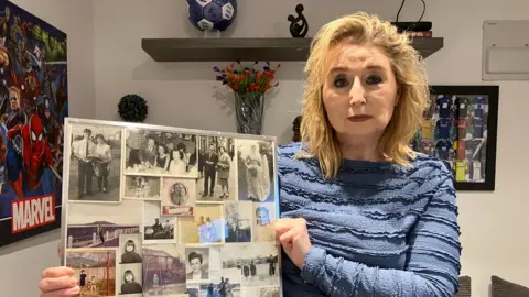 Sue Paige, a woman in a blue long-sleeved too is holding a collage of black and white photos of her parents