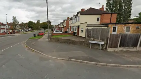 A road junction, with the end of one street at the bottom of the image and another road meeting it on the left of the photo.