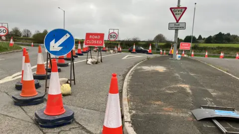 Dozens of traffic cones, and road closed signs at the junction of a dual carriageway.