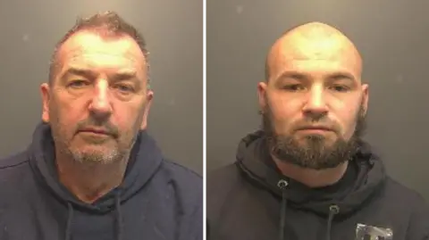 Custody photo of two men wearing black hoodies. They both have facial hair and looking directly into the camera 