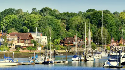 Andy Blakemore MONDAY - The river Bursledon with yachts moored and houses on the opposite bank 