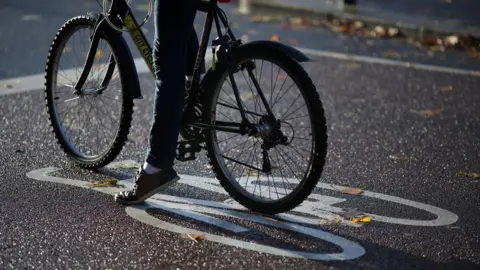 Stock photo of a cyclist waiting at a junction on a designated cycle path.