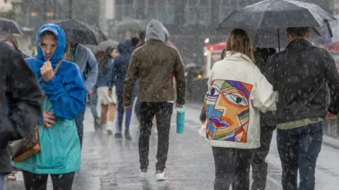 PA Media People walking in the rain