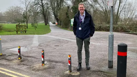 Councillor Nick O'Donnell is standing next to small posts near a park. He is smiling at the camera.