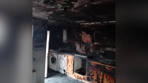 Derek Smith Derek's kitchen, pictured after the fire. It has been badly damaged and it blackened by smoke.