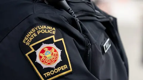 A police officer with "Pennsylvania State Police" written on his badge