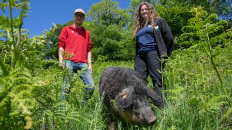 Ellie Wyatt and Finley Binns with a pig